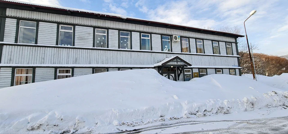 A building partly surrounded by deep snow